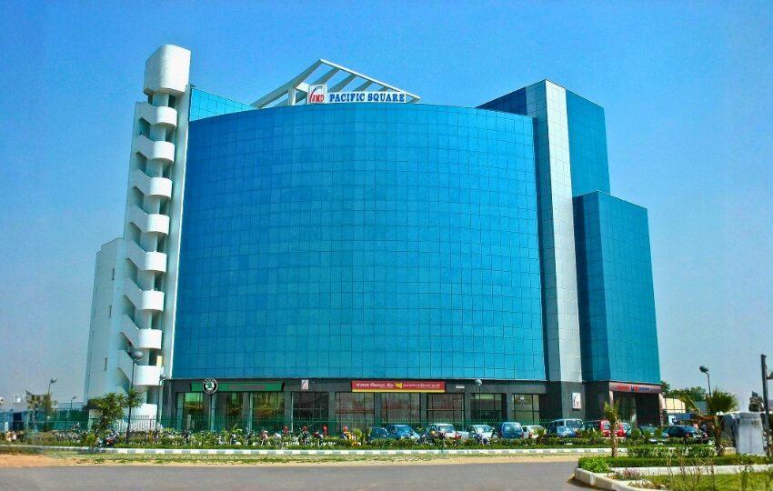 This is a JMD Pacific Square building displaying the grand glass wall front facade positioned right on the Delhi-Jaipur Highway (NH-48), Gurugram.