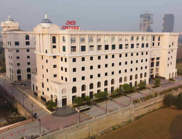 This is a JMD Empire building showcasing a high-angle aerial view of its European-inspired classical architecture, featuring prominent red brand signage and arched retail frontages at the ground level.