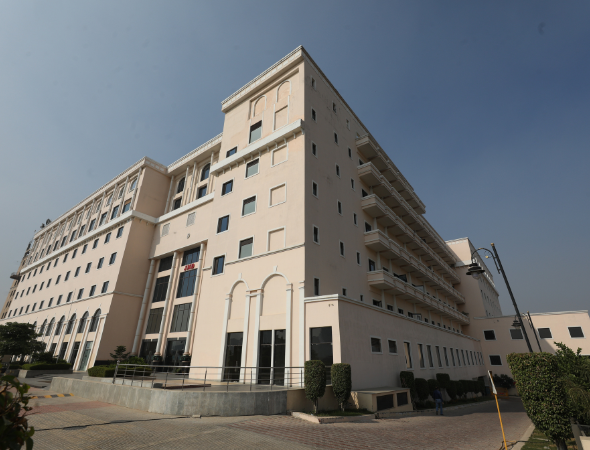 This is a JMD Empire building displaying a low-angle perspective of the multi-story cream facade, highlighting corporate office windows, balcony tiers, and paved perimeter access.