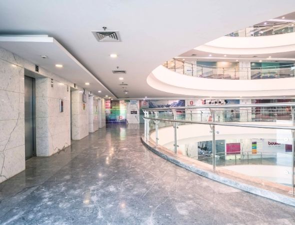 This is a JMD Megapolis building on Sohna Road Gurugram displaying the premium interior architecture of its commercial tech park, highlighting spacious multi-level office lobby corridors for lease.