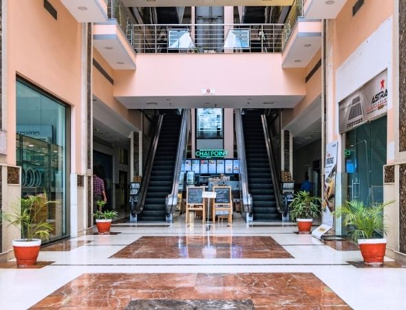 This is the central escalator layout inside JMD Regent Plaza Gurugram, highlighting the main atrium entry points and retail walkthrough zones within the commercial shopping complex.