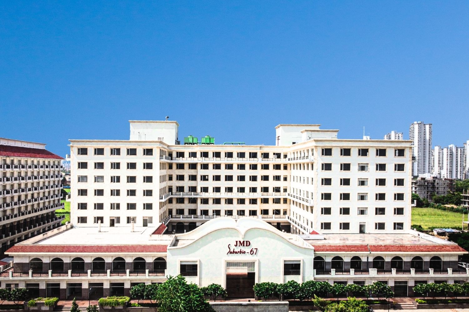 Exterior front view of JMD Suburbio 67 building in Gurugram under a clear blue sky.